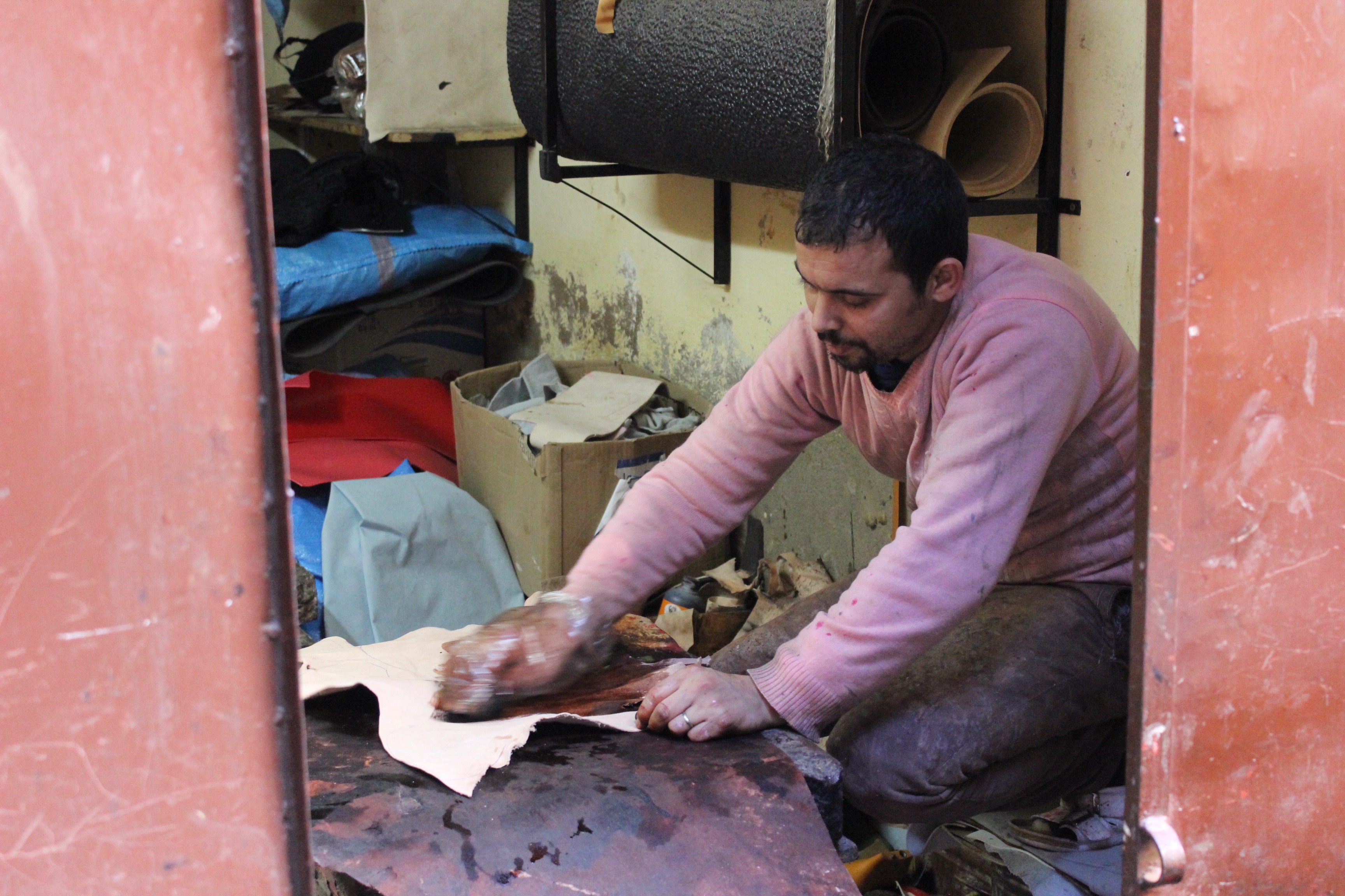 Artisan babouchier de Marrakech préparant le cuir pour la confection de babouches marocaines